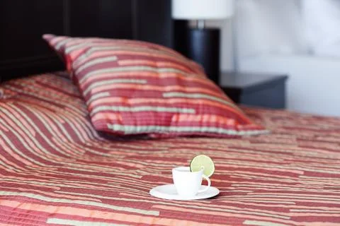 Bed with two pillows, a cup of tea on the blanket Foto stock
