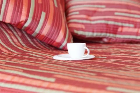 Bed with two pillows, a cup of tea on the blanket Foto stock