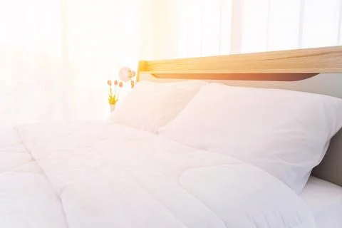 The bed is white and clean with a down duvet and down comforters and orange.. Stock Photos