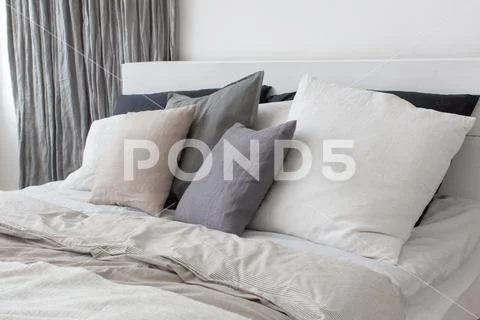 Bed with white and grey linens Stock Photos