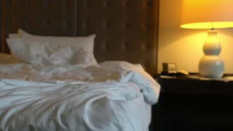 A bed with a white comforter and pillows Stock Footage 313554357