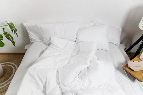 Bed with white linens Stock Photos