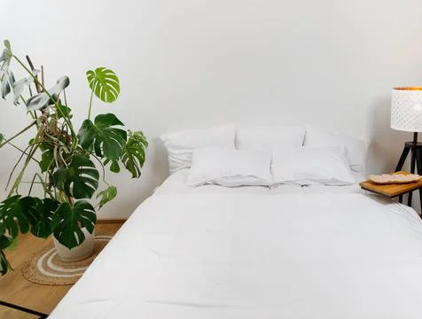 Bed with white linens Stock Photos