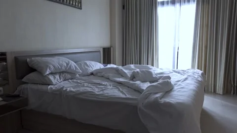A bed with white sheets and pillows. A messy bed in the morning. Stock Footage 294697061