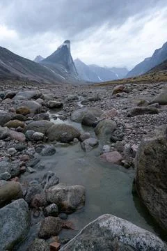 Bed of wild Weasel river in remote arctic valley on a cloudy and rainy day Stock Photos