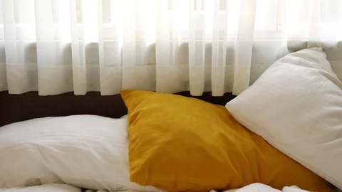 Bed by the window with curtains in the bedroom Video stock 100667406