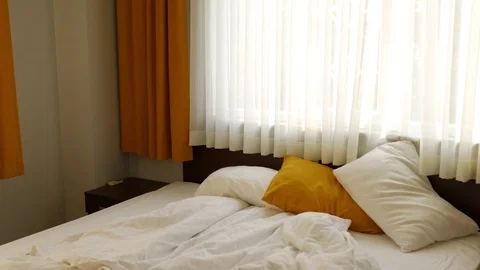 Bed by the window on a sunny morning Video stock 100667464