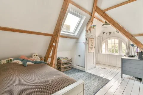 A bedroom with a bed and a window Stock Photos