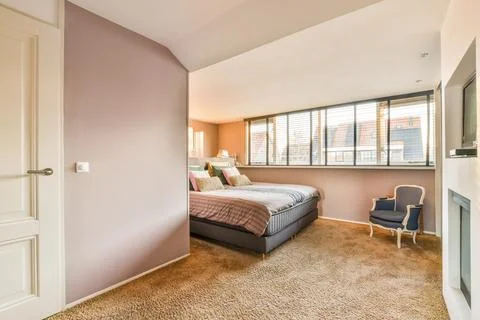 A bedroom with a bed and a window Stock Photos