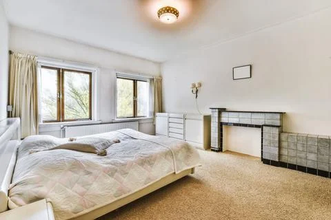 Bedroom with a double bed covered with a light bedspread Stock Photos