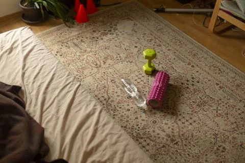 Bedroom floor with exercise gear on patterned rug Stock Photos