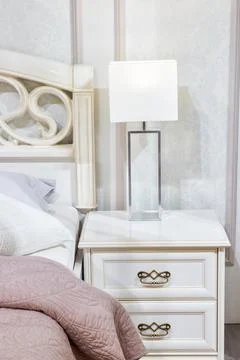 Bedroom interior, bed with pillows and blanket, lamp is on the bedside table Stock Photos