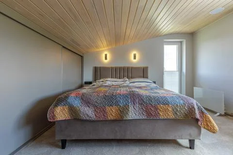 Bedroom Interior with Double Bed and Sloped Wooden Ceiling Photos