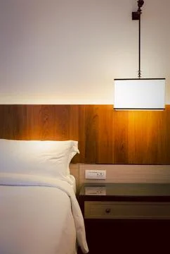 Bedroom interior elements with stylish ceiling lamp on bedside table indoor. Stock Photos