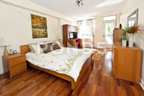 Bedroom interior with hardwood floor Stock Photos
