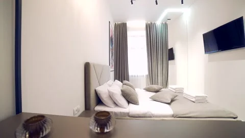 Bedroom interior, modern style, large bed, light colors, white, pink, beige Stock Footage 152509695