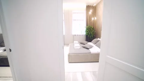 Bedroom interior, modern style, large bed, light colors, white, pink, beige Stock Footage 152509853