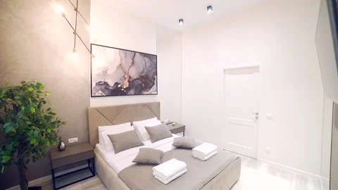 Bedroom interior, modern style, large bed, light colors, white, pink, beige Stock Footage 152509869