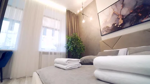 Bedroom interior, modern style, large bed, light colors, white, pink, beige Stock Footage 152509998