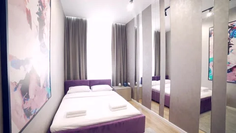 Bedroom interior, modern style, large bed, light colors, white, pink, beige Stock Footage 152510094