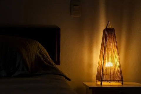 Bedroom lamp lit on the bedside table. bedroom concept. Hostel concept. copy  Stock Photos