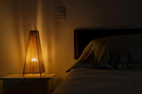 Bedroom lamp lit on the bedside table. bedroom concept. Hostel concept. copy  Stock Photos