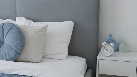 Bedroom scene showcasing a bedside table with clocks. Close-up of clocks on the Stock Footage 274317663
