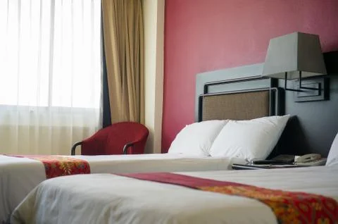 Beds with pillows and table between in luxury hotel room Stock Photos