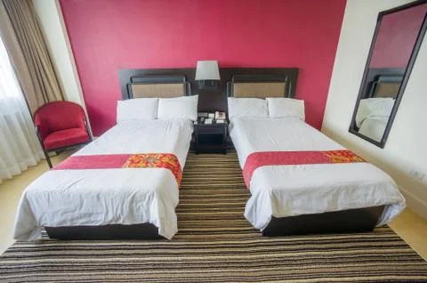 Beds with pillows and table between in luxury hotel room Stock Photos