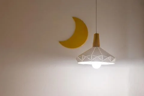 Bedside light on a white wall with moon in the background. Copy space Stock Photos