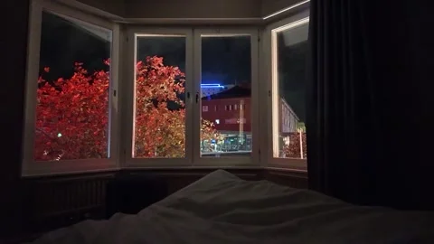 Bedside Night View through Bay Window with Red Trees and City Lights 스톡 동영상 347682313
