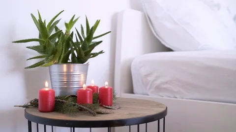 Bedside table with authentic Chrismas decoration and lit candles. 스톡 동영상 102656728