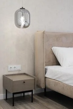 Bedside table with hanging lamp 스톡 사진