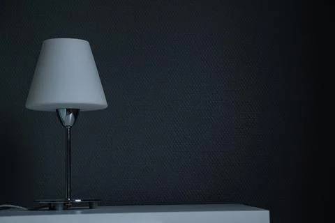 Bedside table with lamp. Dark wall. Place for text. Stock Photos