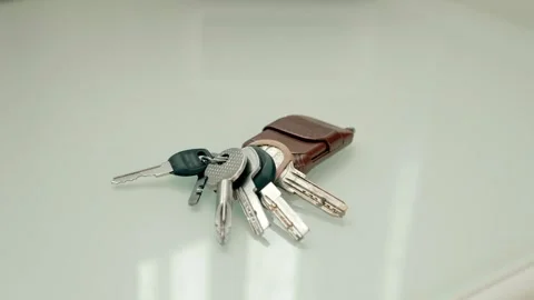 On bedside table lies a bunch of house keys and a man's hand takes them Video stock 297804603