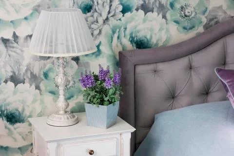 Bedside table, light fixture, pot with flower, interior in Provence style Stock Photos