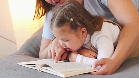 Bedtime reading session between a caregiver and a child Stock Footage 333518144