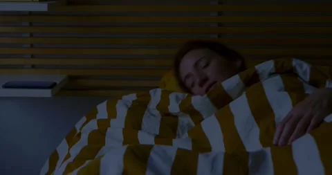 Bedtime Routine: Woman Adjusts Sheets Next to Sleeping Dog. Stock Footage 323389421