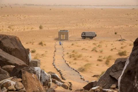 Beduin walking to stone flat near ancient neolithic village in the Sahara 스톡 사진