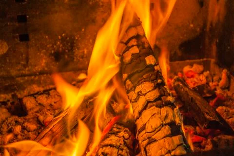 Beech log burning in barbecue with nice warm yellow flame Stock Photos