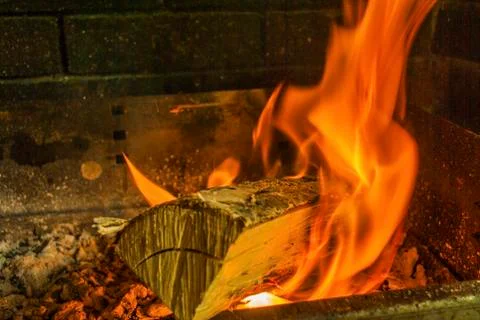 Beech log burning in barbecue with nice warm yellow flame Stock Photos