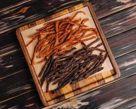 Beef and chiken jerky on wooden board Stock Photos