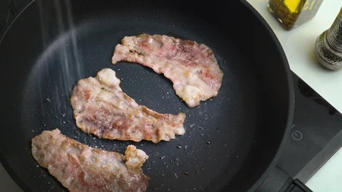 Beef bacon frying in a pan marbled thin beef Stock Footage 124134457