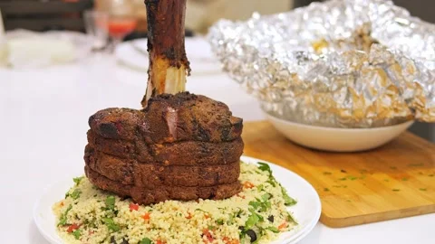 Beef on bone served with garnish on plate, highlighting rich flavor and tender Stock Footage 276170980