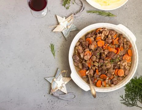 Beef bourguignon or meat stew with vegetables and herbs in a casserole. Stock Photos