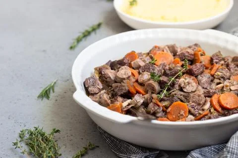 Beef bourguignon or meat stew with vegetables and herbs in a casserole. Stock Photos