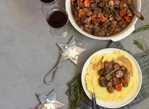 Beef bourguignon or meat stew with vegetables and herbs in a casserole. Stock Photos