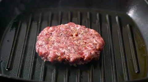Beef burger patties grilling on a griddle pan Stock Footage 65757901