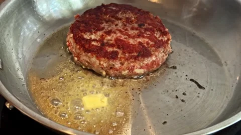 Beef Burger Patty Searing in Melted Butter on Stainless Steel Pan Stock Footage 341542333