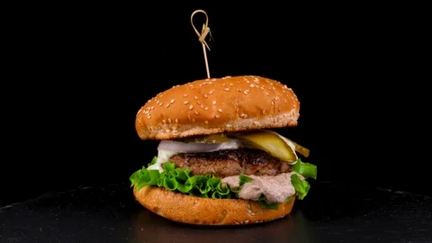 Beef burger with pickled cucumbers and mushroom sauce, on black stone tray Stock Footage 84652810